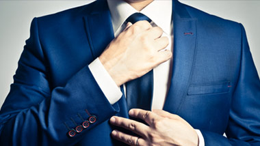 man adjusting his tie