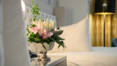 Image of hotel bed and side table with flowers