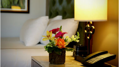 Image of hotel bed and side table with flowers